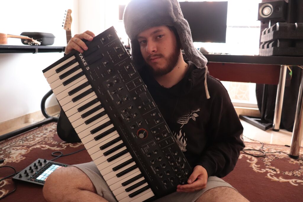 Musician, Tysu, from Colombia, holding his Take 5 synthesizer.